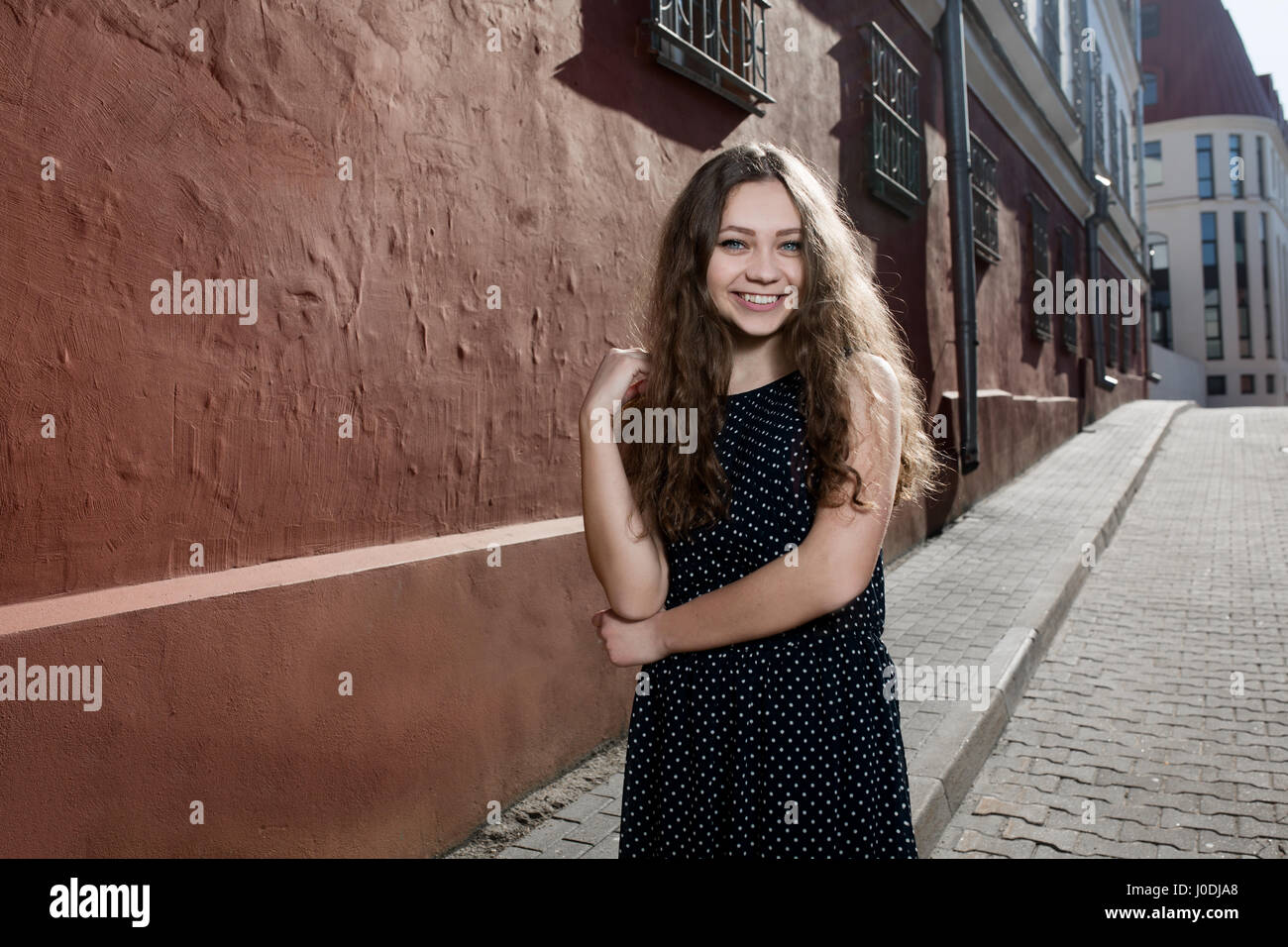 Schöne Brünette junge Frau Kleid und auf der Straße laufen. Fackel für Text und Gestaltung. Lebensstil in der Stadt Stockfoto