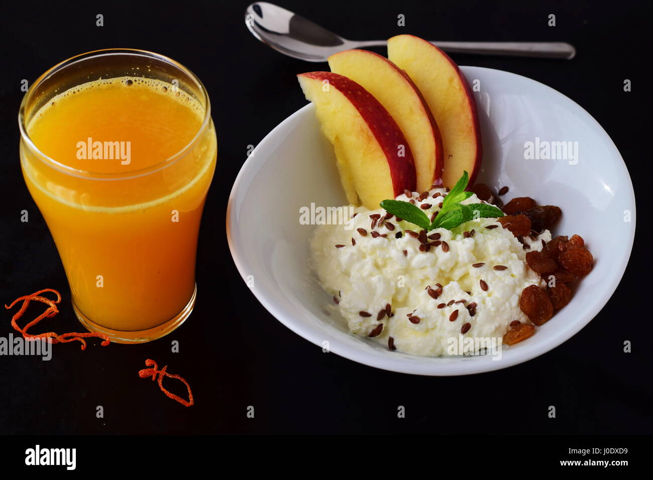 Gesundes Frühstück: Quark mit Leinsamen, Rosinen, frische Äpfel und ein Glas frisch gepressten Orangensaft. Gesunde Ernährung-Konzept. Stockfoto