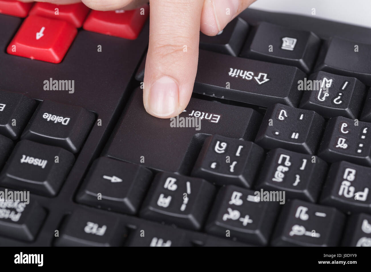 Finger drückt enter-Taste auf der Tastatur des Computers Stockfoto