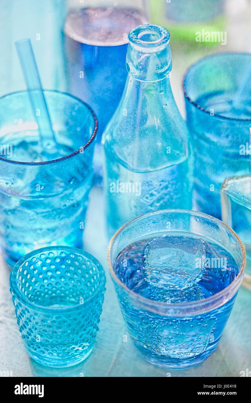 Blauen Trinkflaschen und Glas draußen im Regen Stockfoto