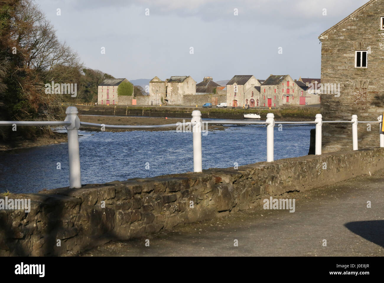 Riverside walk auf dem River Lennon in Ramelton, County Donegal, Irland, mit alten Lager befinden im Hintergrund. Stockfoto