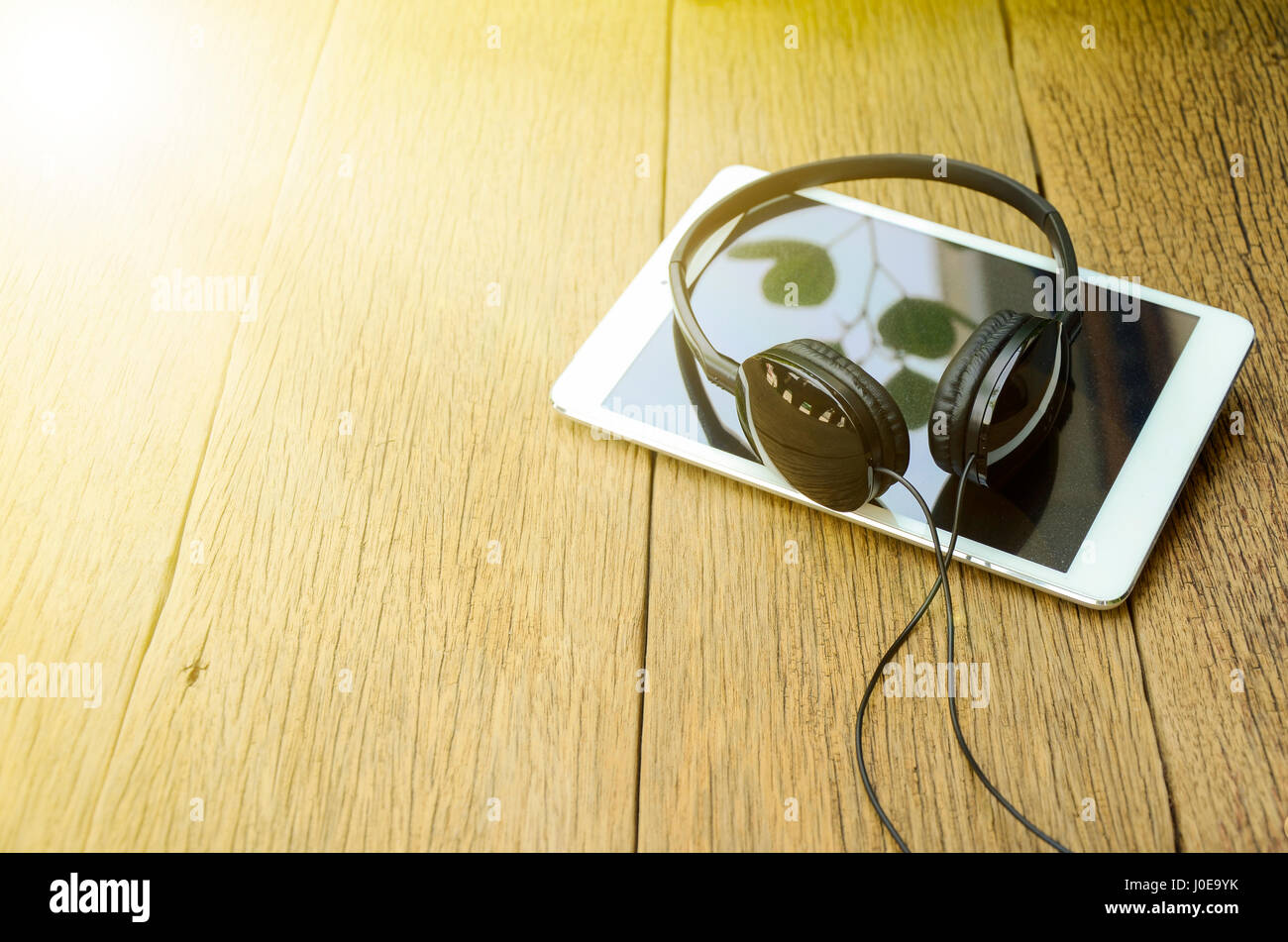 Kopf Telefon und Computer Tablet auf alten Holztisch Hintergrund in weichen und warmen hellen Ton. Stockfoto