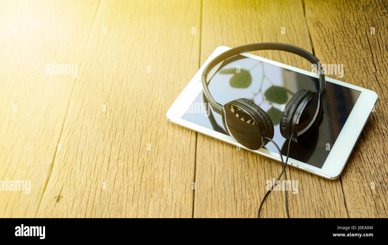 Kopf Telefon und Computer Tablet auf alten Holztisch Hintergrund in weichen und warmen hellen Ton. Stockfoto