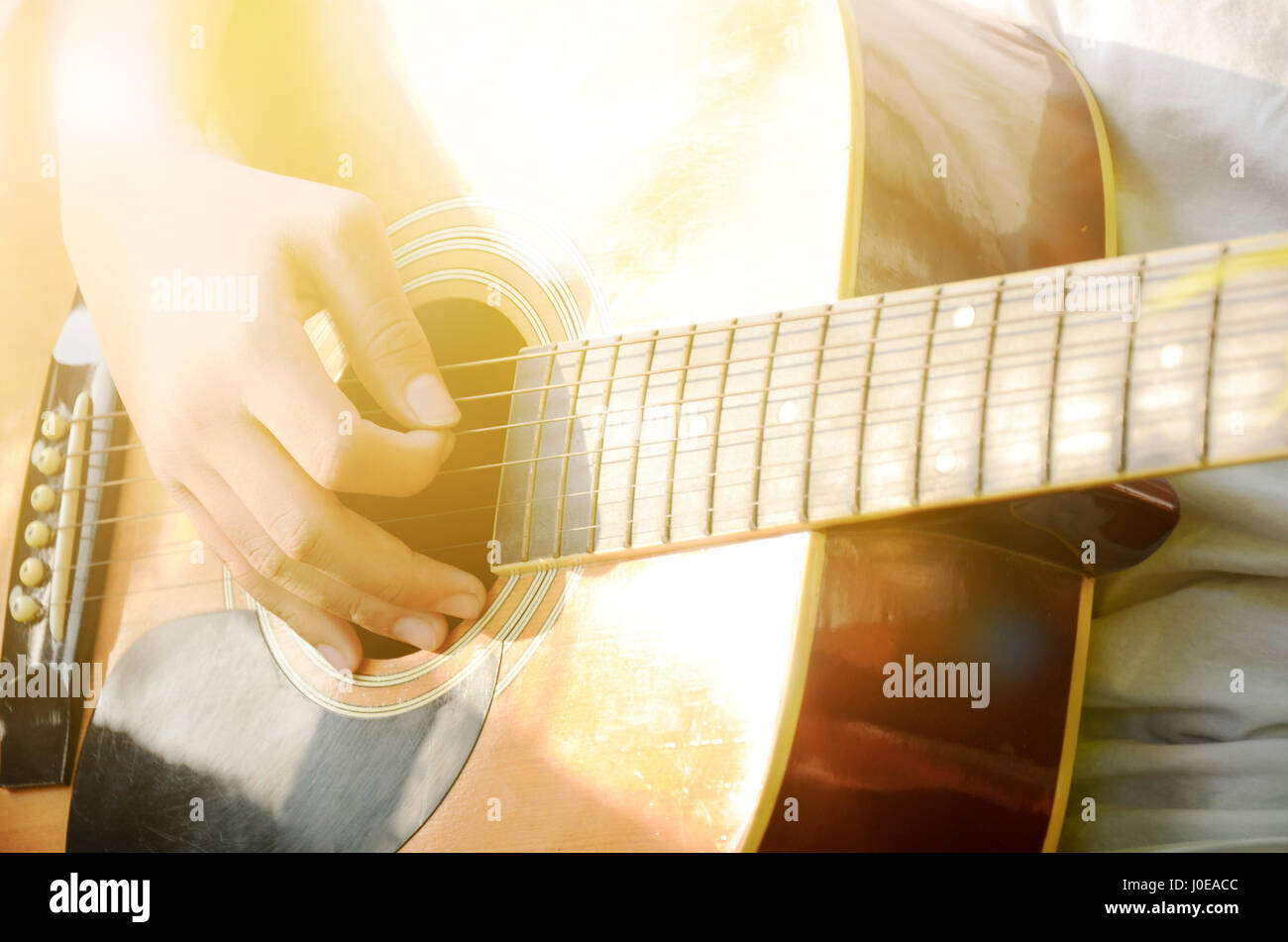 Nahaufnahme der Hand spielte Gitarre in warmen hellen Ton. Stockfoto