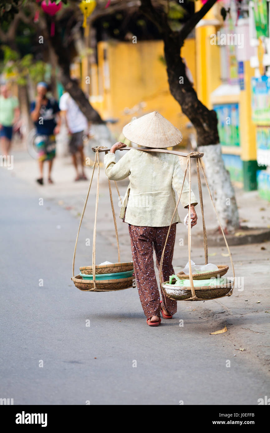Hoi an, Vietnam - 14. März 2017: Vietnamesin ist in traditioneller Weise die Güter transportieren. Stockfoto