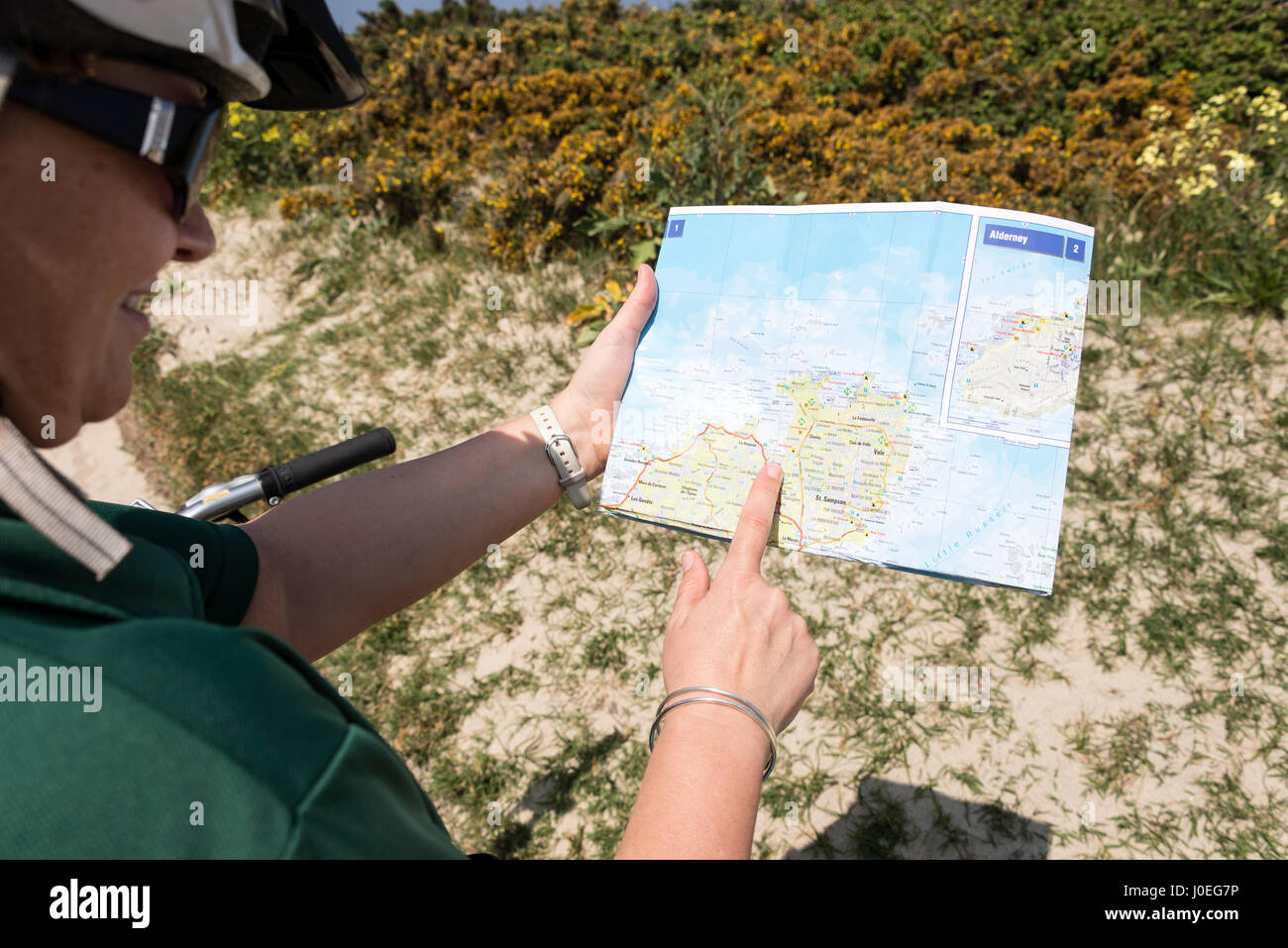 Ein Radfahrer, ein Blick auf ihre Karte der nördlichen Küste von Guernsey auf den Kanalinseln, Großbritannien. Stockfoto