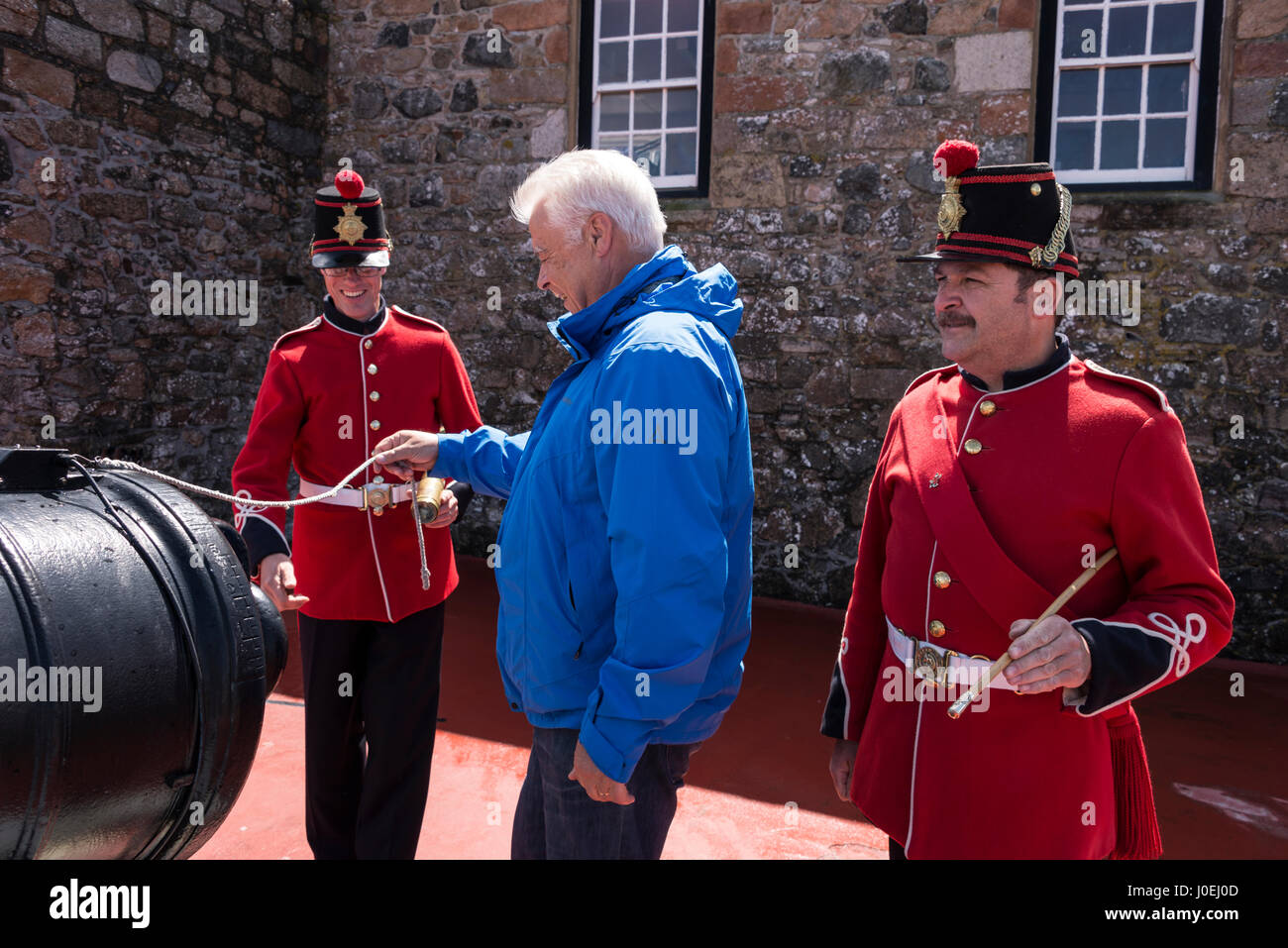 PIX zeigt: ein Besucher versucht, seine Hand an ziehen am Kabel an der Mittag-Pistole, es eines der großen Besucher-Attraktion, ist wenn zwei militärisch Hüter uniformierten, Stockfoto