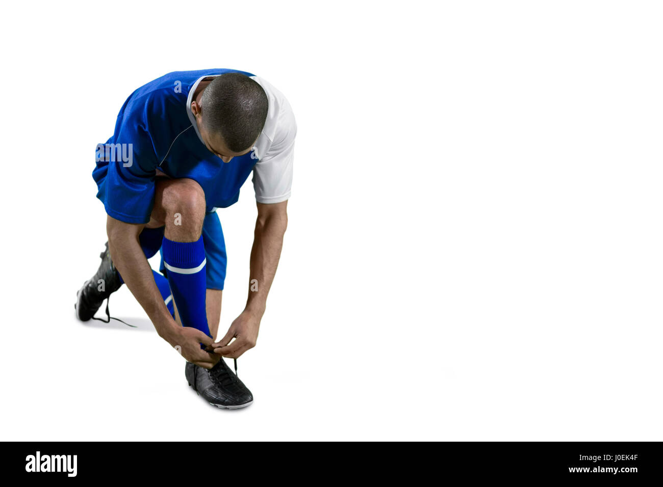 Football-Spieler binden seine Schnürsenkel auf weißen Hintergrund Stockfoto