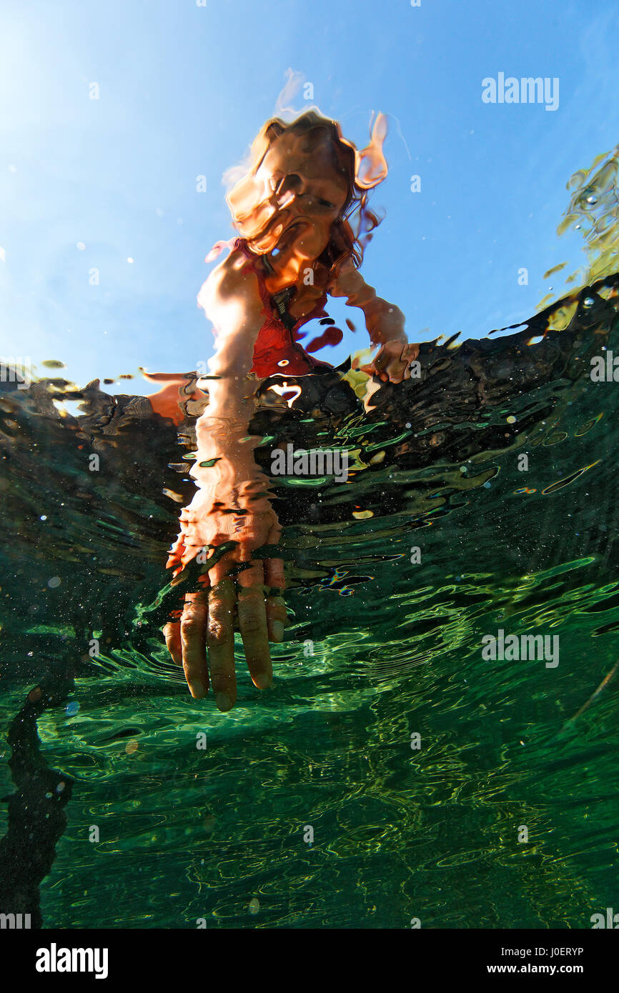 Unterwasseransicht eines Mädchens, das an einem heißen Tag auf den Plitvicer Seen in Kroatien abkühlt Stockfoto