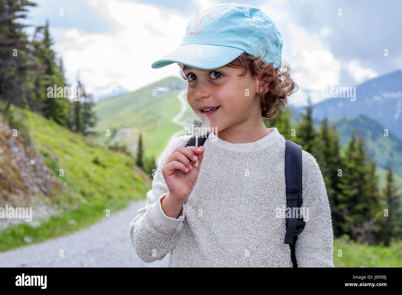 5 Jahre alten Trekker Mädchen mit Löwenzahn Stockfoto