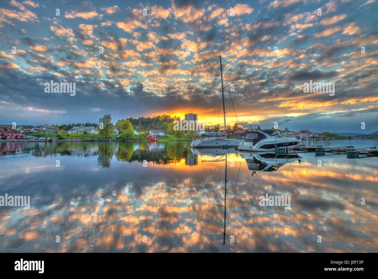 Erstaunlich, bunt, wunderbaren Sonnenuntergang über das Cit und den Fluss in Porsgrunn, Norwegen. Wolken sind in Farben gewaschen und der Himmel spiegelt sich im Wasser Stockfoto