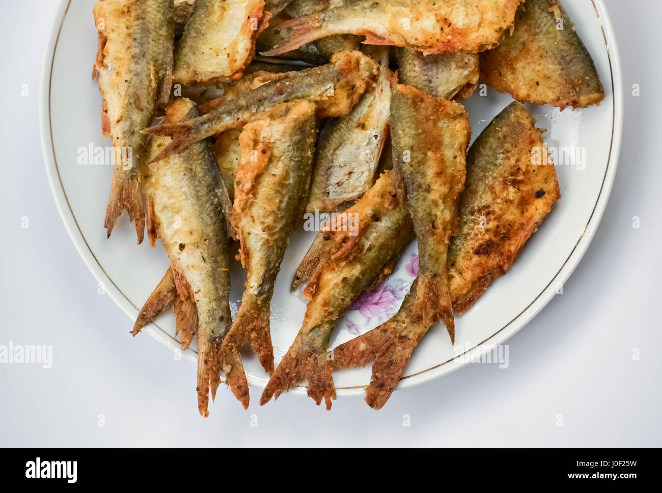 Nahaufnahme einer Platte mit gebratenen Fisch auf hellem Hintergrund Stockfoto