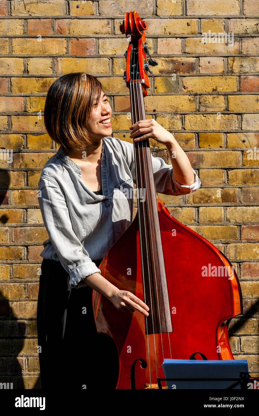 Eine junge Musikerin Straßenmusik In Brick Lane, London, England Stockfoto