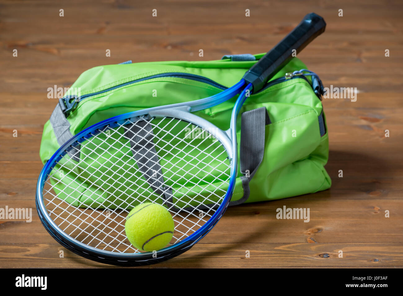 Grün Sport-Tasche und einen Schläger für ein Spiel des Tennis hautnah auf dem Boden Stockfoto