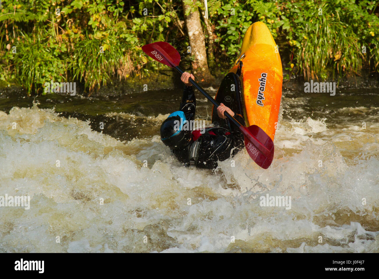 Männliche Kajaker in Stromschnellen des Flusses Tryweryn auf nationaler White Water Centre in der Nähe von Bala in Nord Wales geworfen Stockfoto