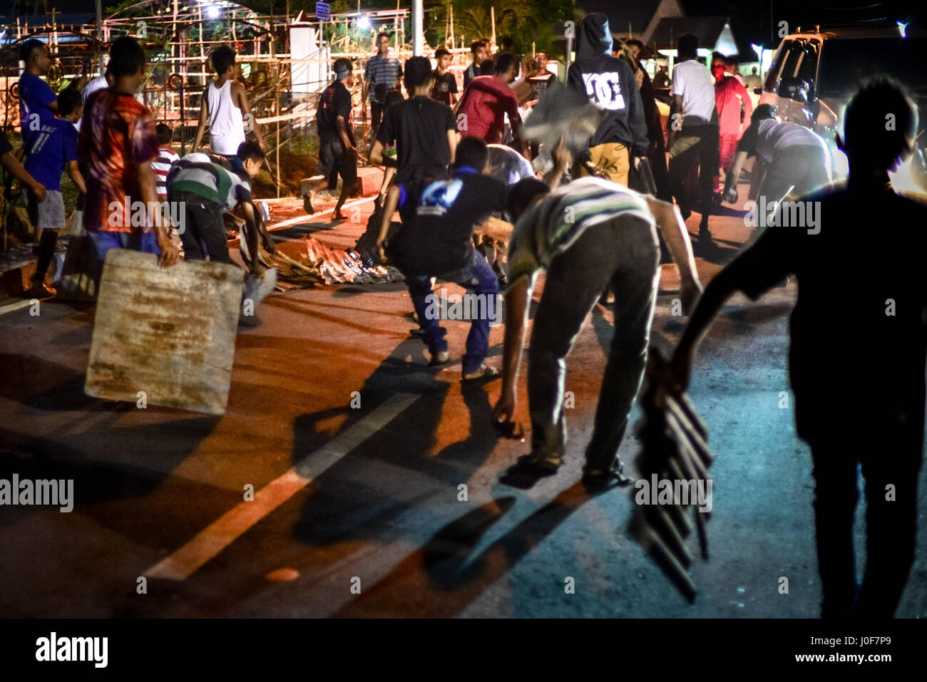 Junge Männer, die Geräusche durch ziehen Zinkplatten auf dem Weg als Teil des Shackled Mittwoch Gedenkfeiern in Larantuka, Indonesien. Stockfoto