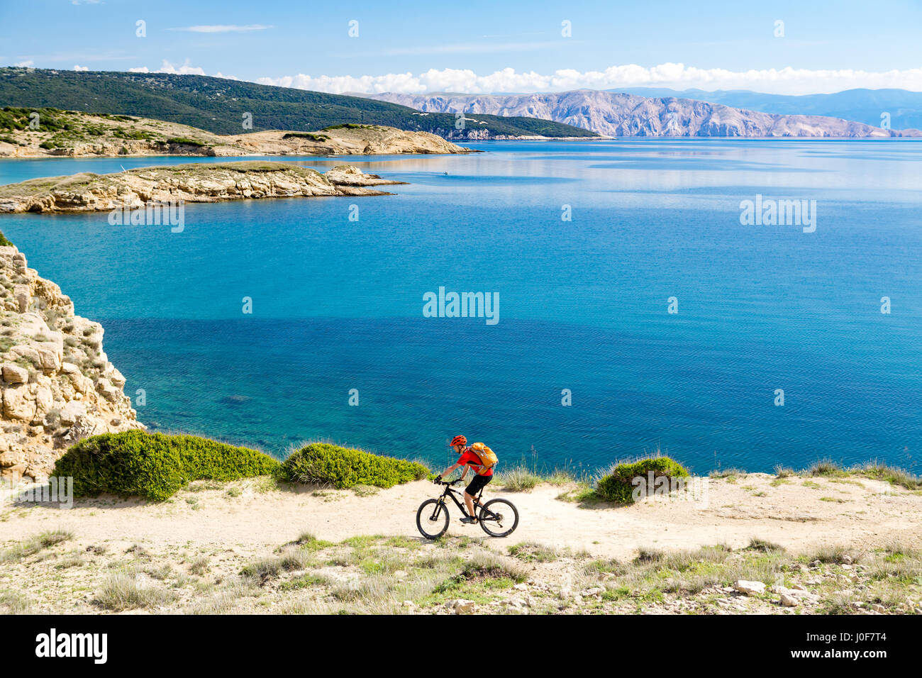 Mountainbiker am Fahrrad im Sommer oder Herbst inspirierend Berge Landschaft reiten. Mann Radsport MTB Enduro trail Strecke am Meer und felsigen Schmutz p Stockfoto