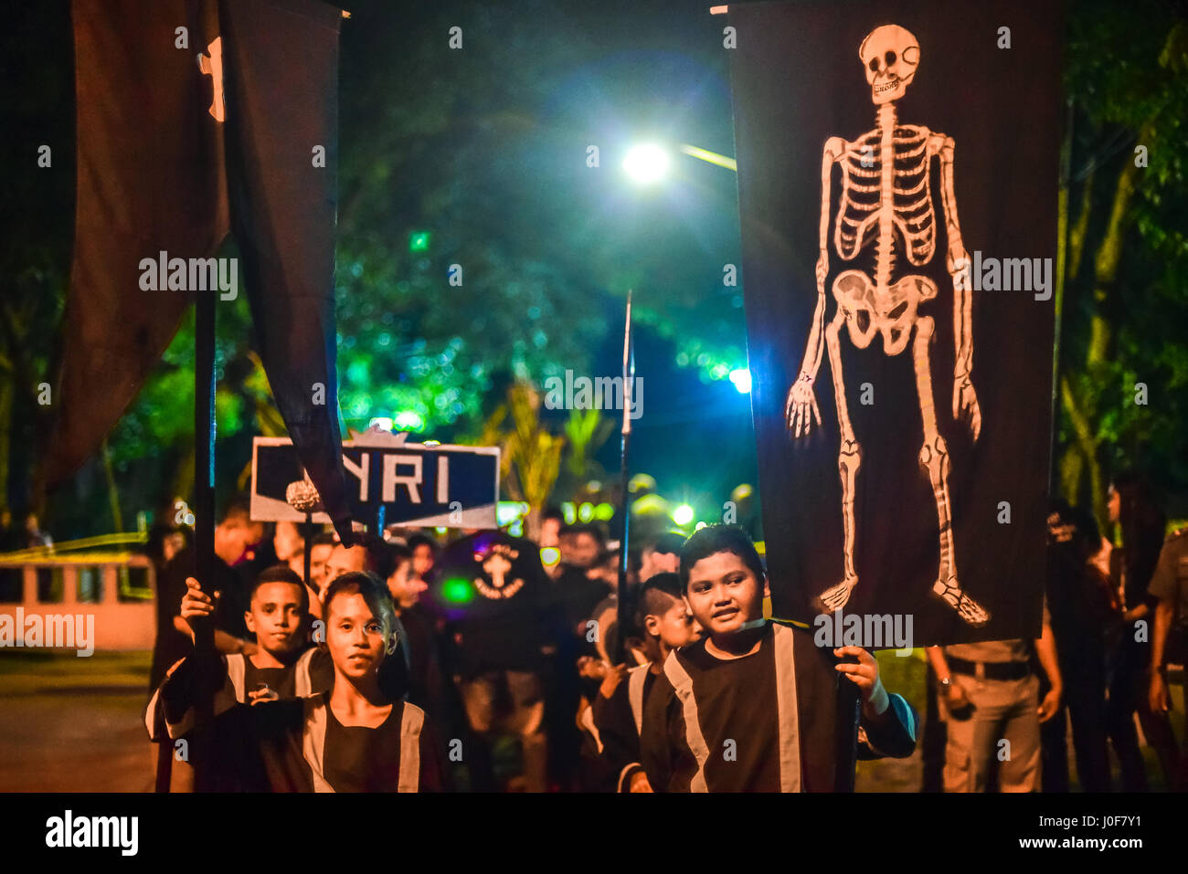 Kinder bringen Fahnen und Symbole während der Semana Santa Prozession in Larantuka, Indonesien. Stockfoto