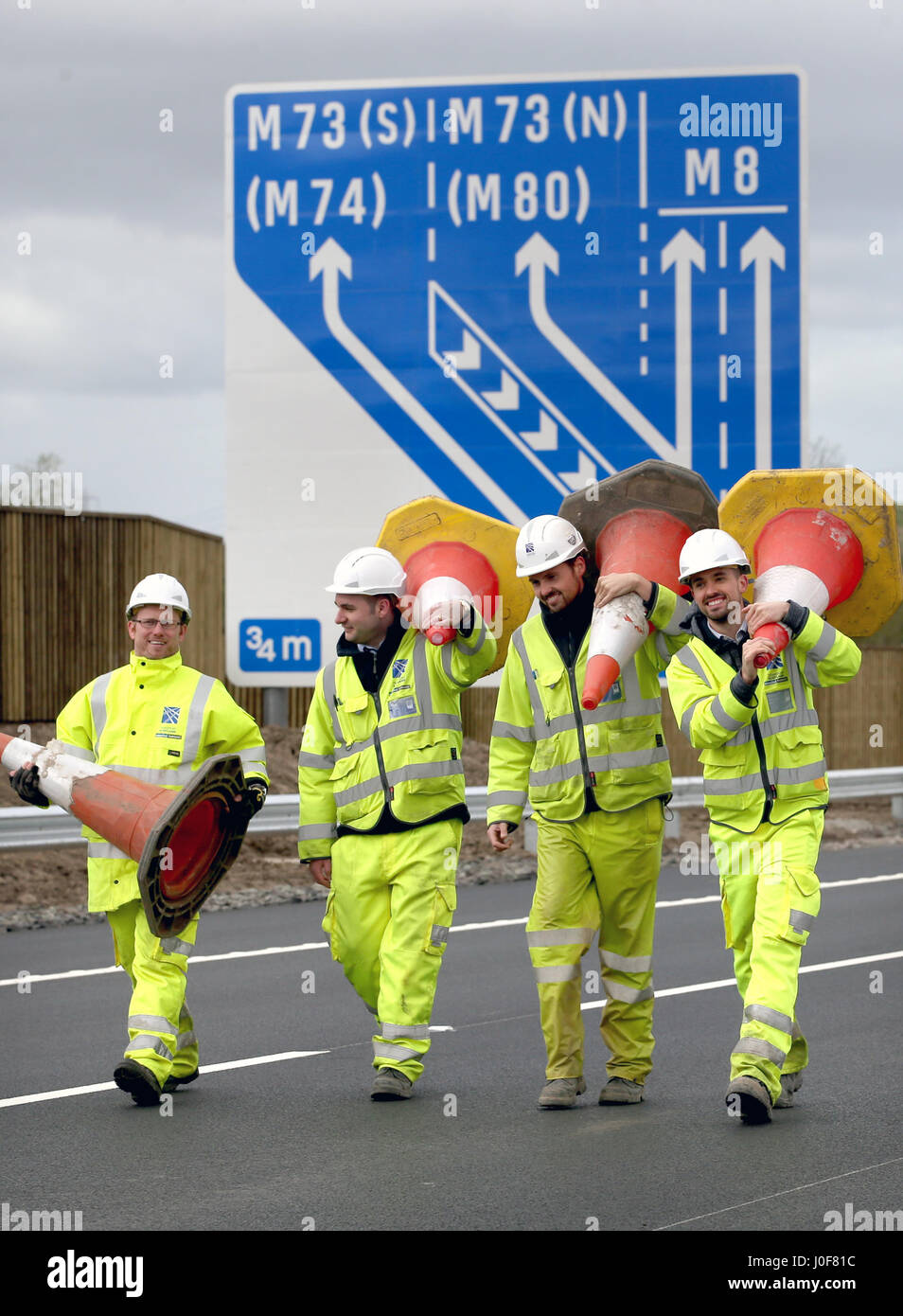 Ingenieure aus Transport Schottland sammeln die letzten paar Zapfen aus den neuen Abschnitt auf der M8 Autobahn in der Nähe von Ballieston, North Lanarkshire, die für den Verkehr fast eine Woche vor der Zeitplan öffnen. Stockfoto