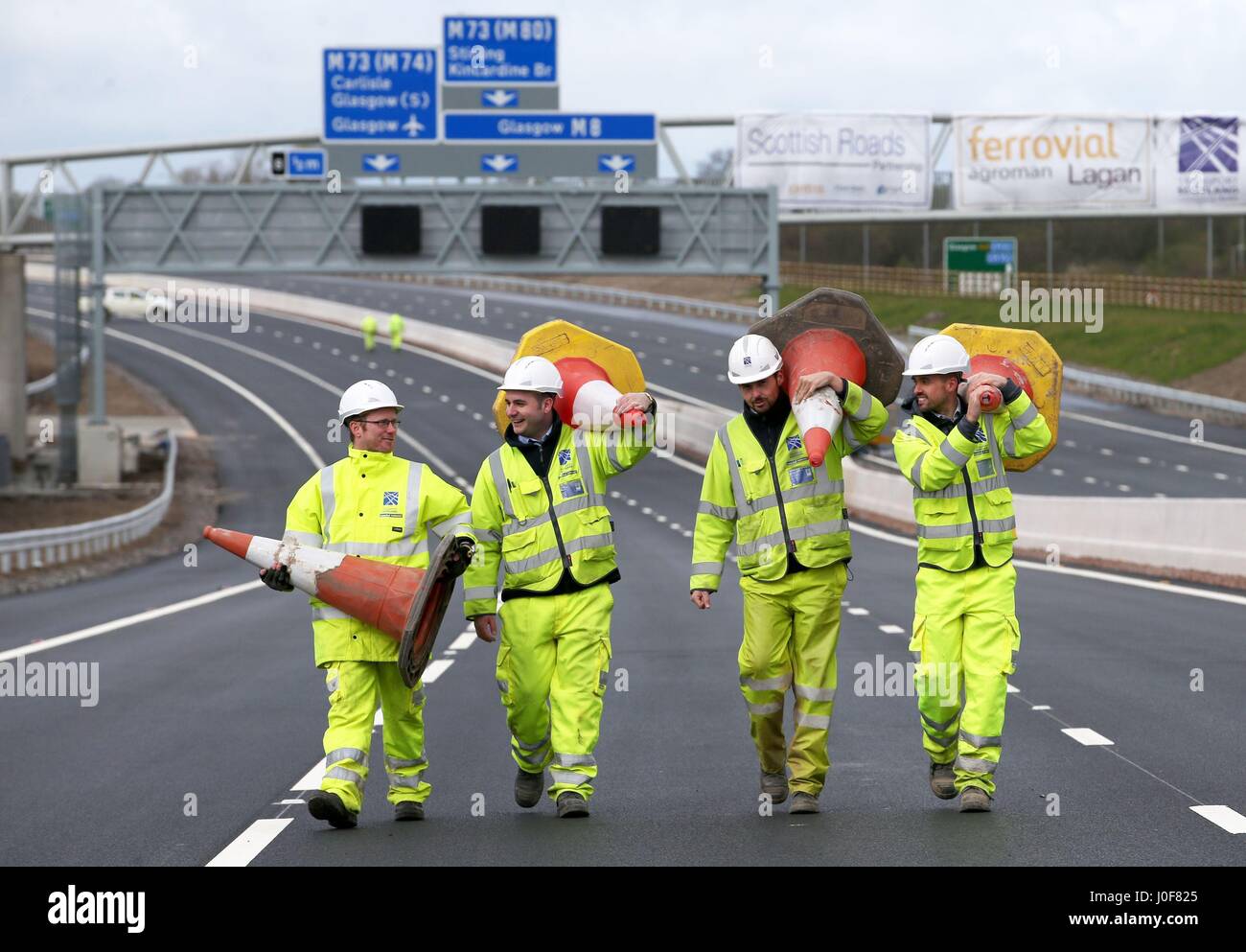 Die Ingenieure von Transport Scotland sammeln die letzten Kegel auf dem neuen Abschnitt der Autobahn M8 in der Nähe von Ballieston, North Lanarkshire, der fast eine Woche vor dem Zeitplan für den Verkehr geöffnet werden soll. Stockfoto