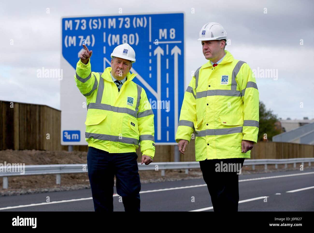 Wirtschaft und Infrastruktur Sekretär Keith Brown (links) und Transport Schottland Project Manager Graeme Reid auf den neuen Abschnitt auf der M8 Autobahn in der Nähe von Ballieston, North Lanarkshire, das für den Verkehr fast eine Woche vor der Zeitplan eröffnet. Stockfoto
