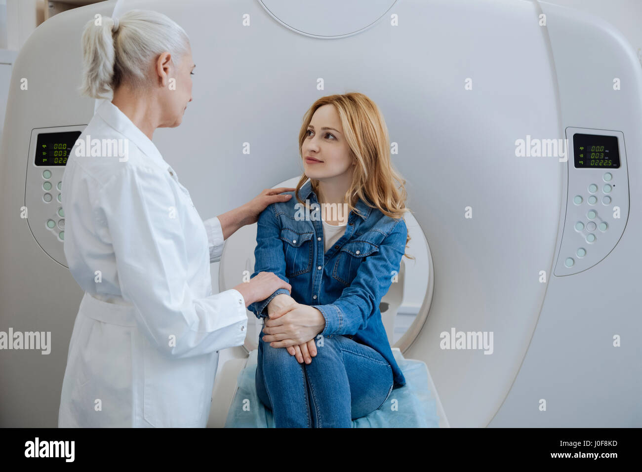 Angenehme freundliche Arzt legte ihre Hand auf die Schulter des Patienten Stockfoto