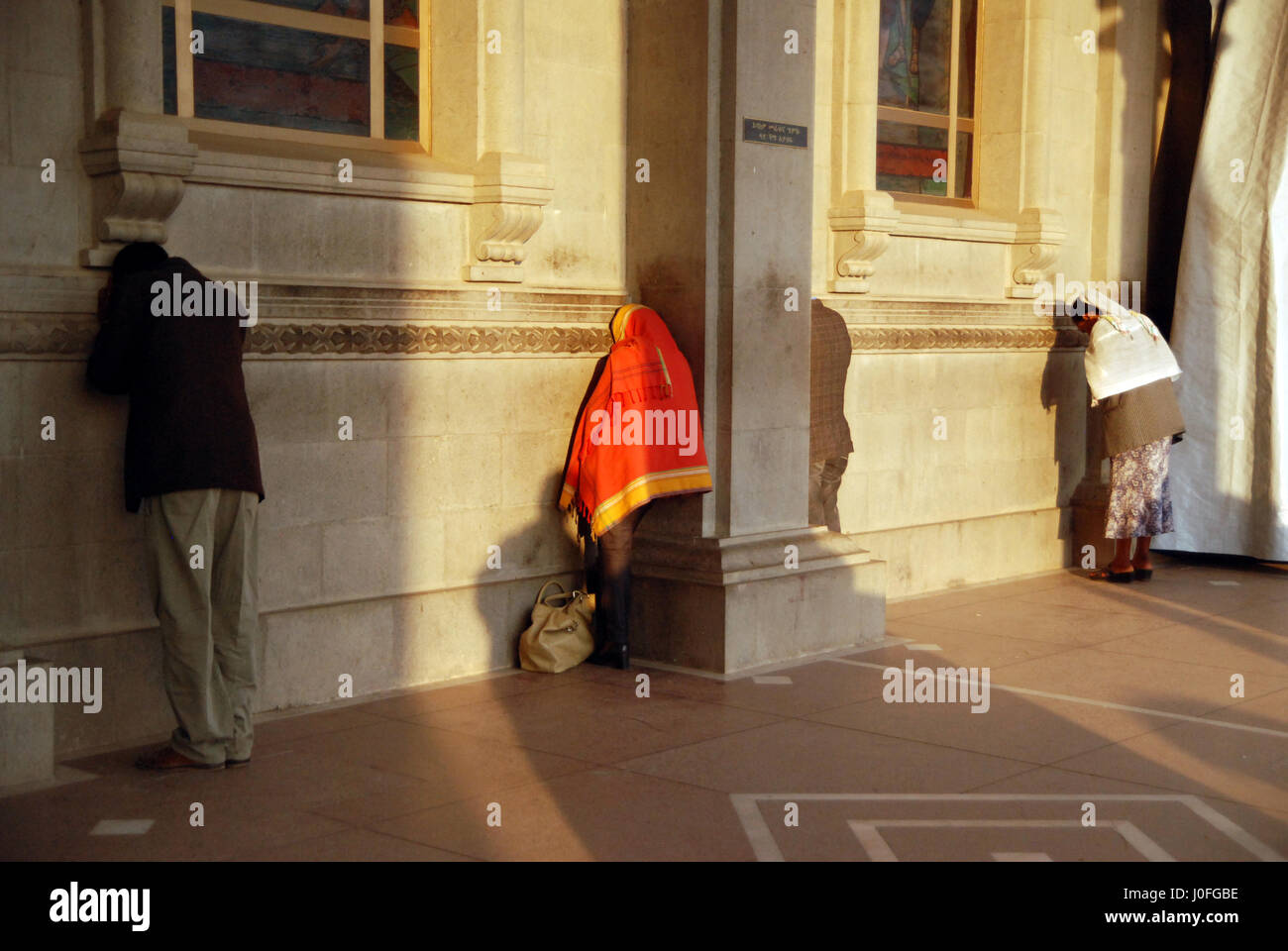 Zwei Frauen und ein Mann, der betet an der Wand der Medhinalem Kirche in Addis Abeba Stockfoto