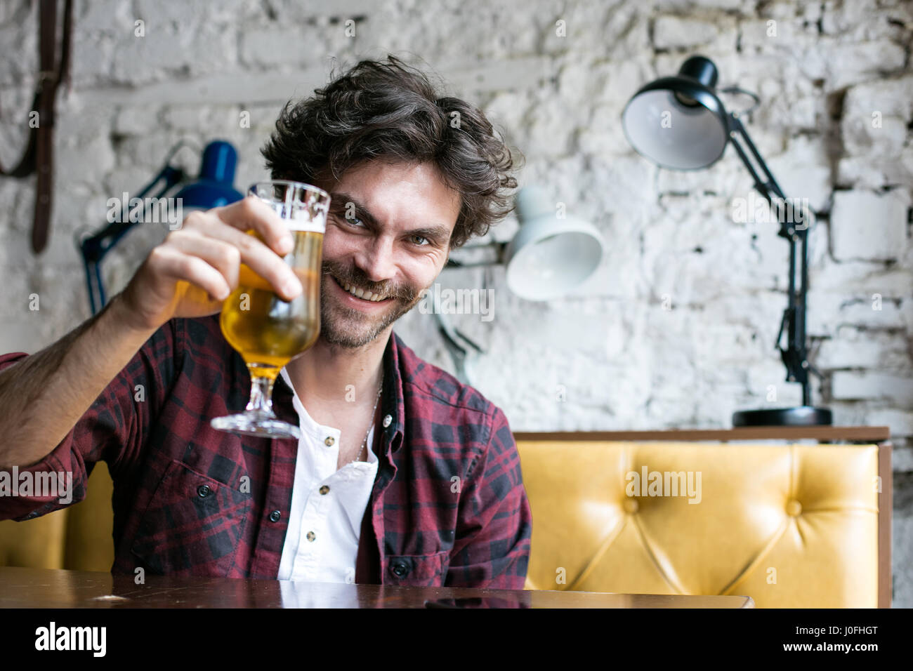 attraktive glücklich entspannen und haben ein Bier in einem Pub, allein an einem Tisch sitzen Stockfoto