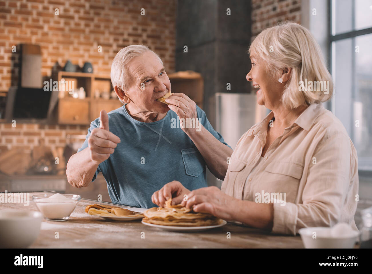 älteres paar essen Pfannkuchen in der Küche zu Hause Stockfoto