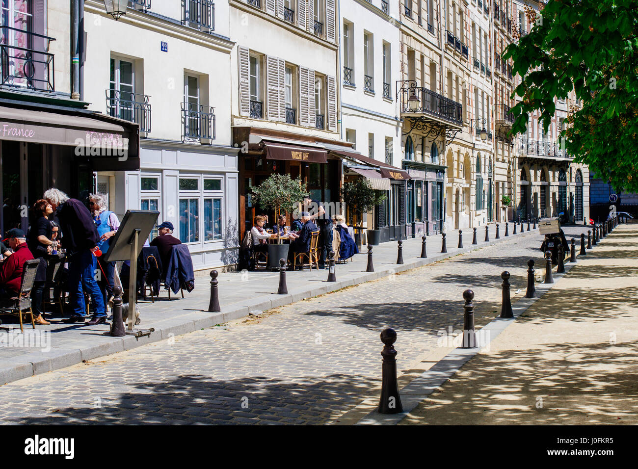 Eine Straße in Paris, Frankreich, mit Restaurants und Bars an einem sonnigen Tag. Stockfoto