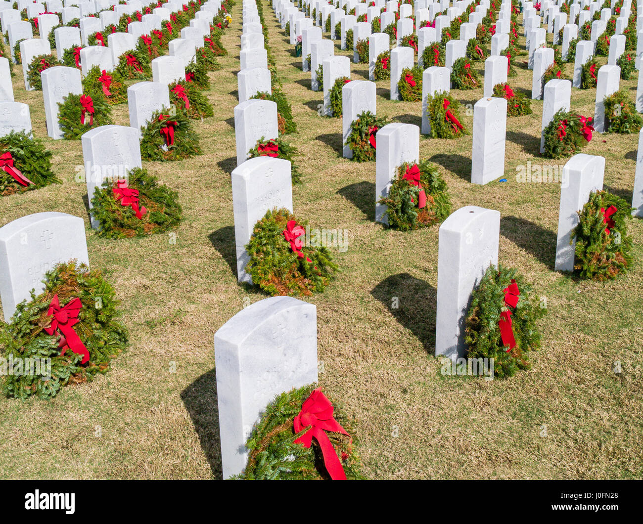 Reihen von Grabsteinen mit Kränzen & roten Bögen in Sarasota National Cemetery in Sarasota Florida Stockfoto