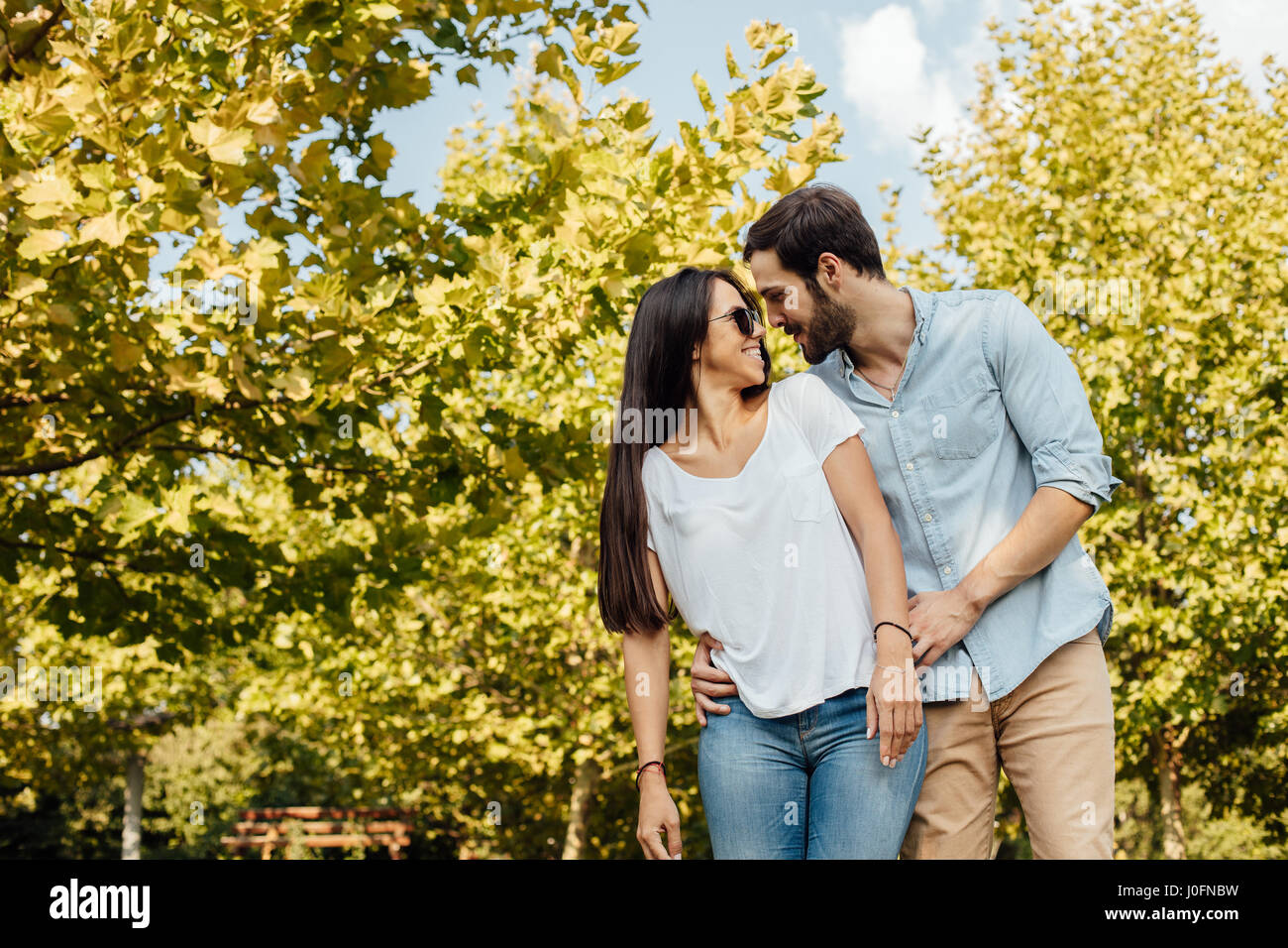 junges Paar Liebende einander draußen im park Stockfoto