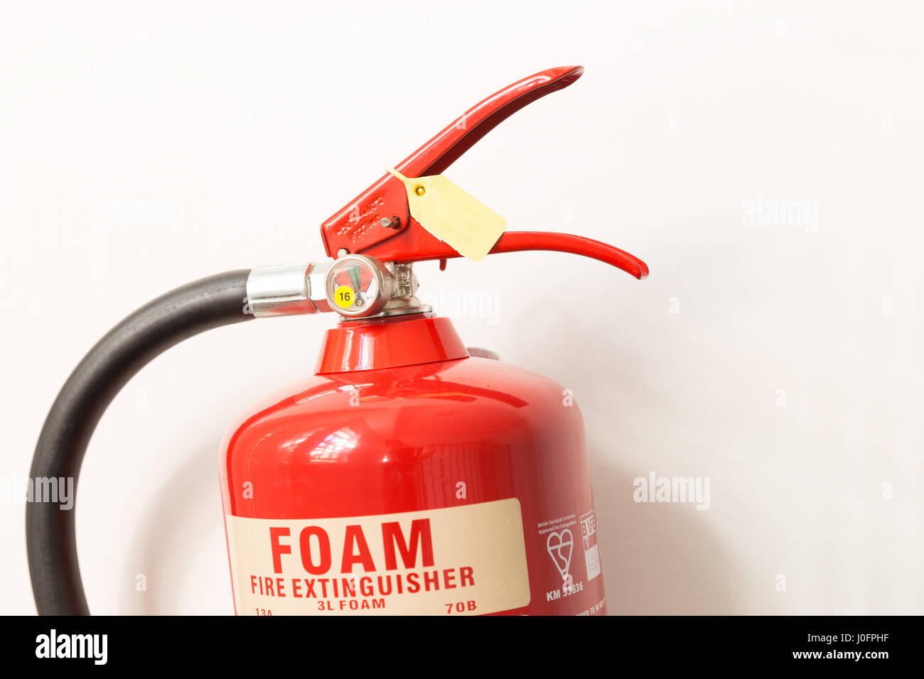 roten Feuerlöscher an der Wand hängen Stockfoto