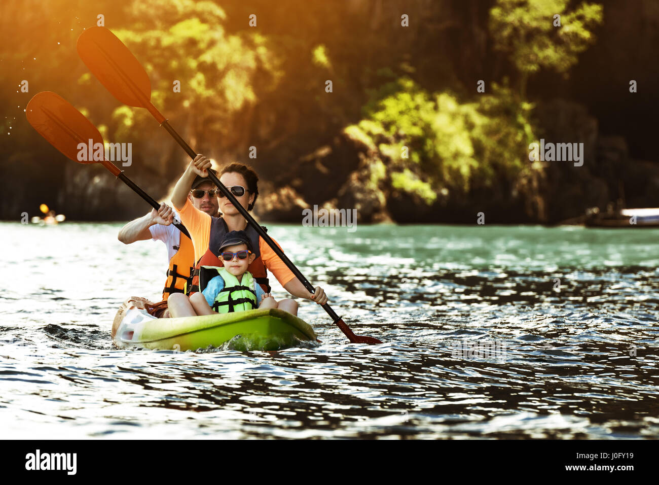 Glückliche Familie von drei Kajakfahren im Meer Bucht im Tropical islands Hintergrund Stockfoto