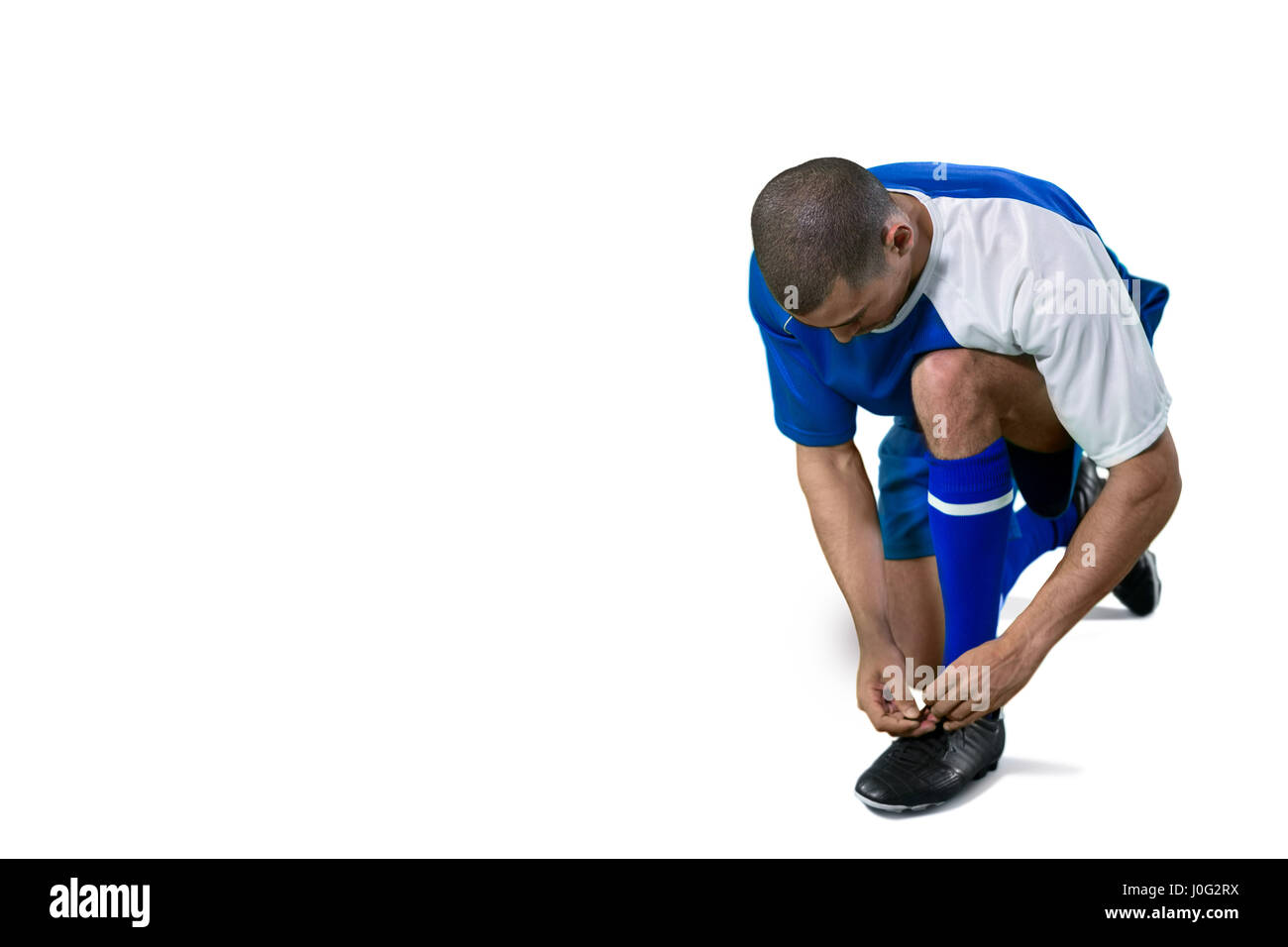 Football-Spieler binden seine Schnürsenkel auf weißen Hintergrund Stockfoto