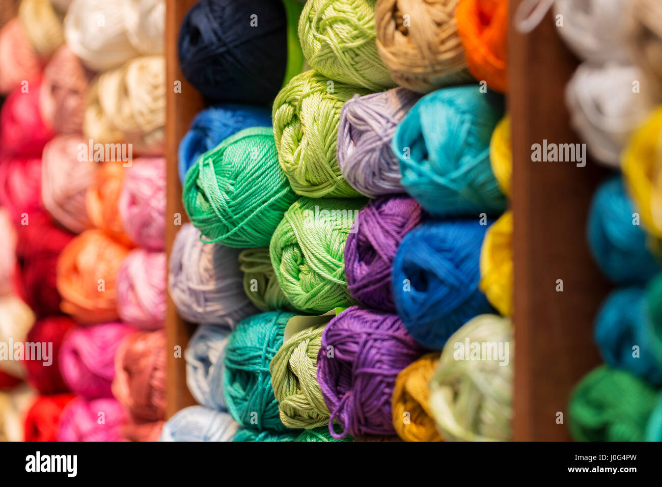 Regale mit bunter Wolle und Garn im Ladengeschäft stricken Stockfoto