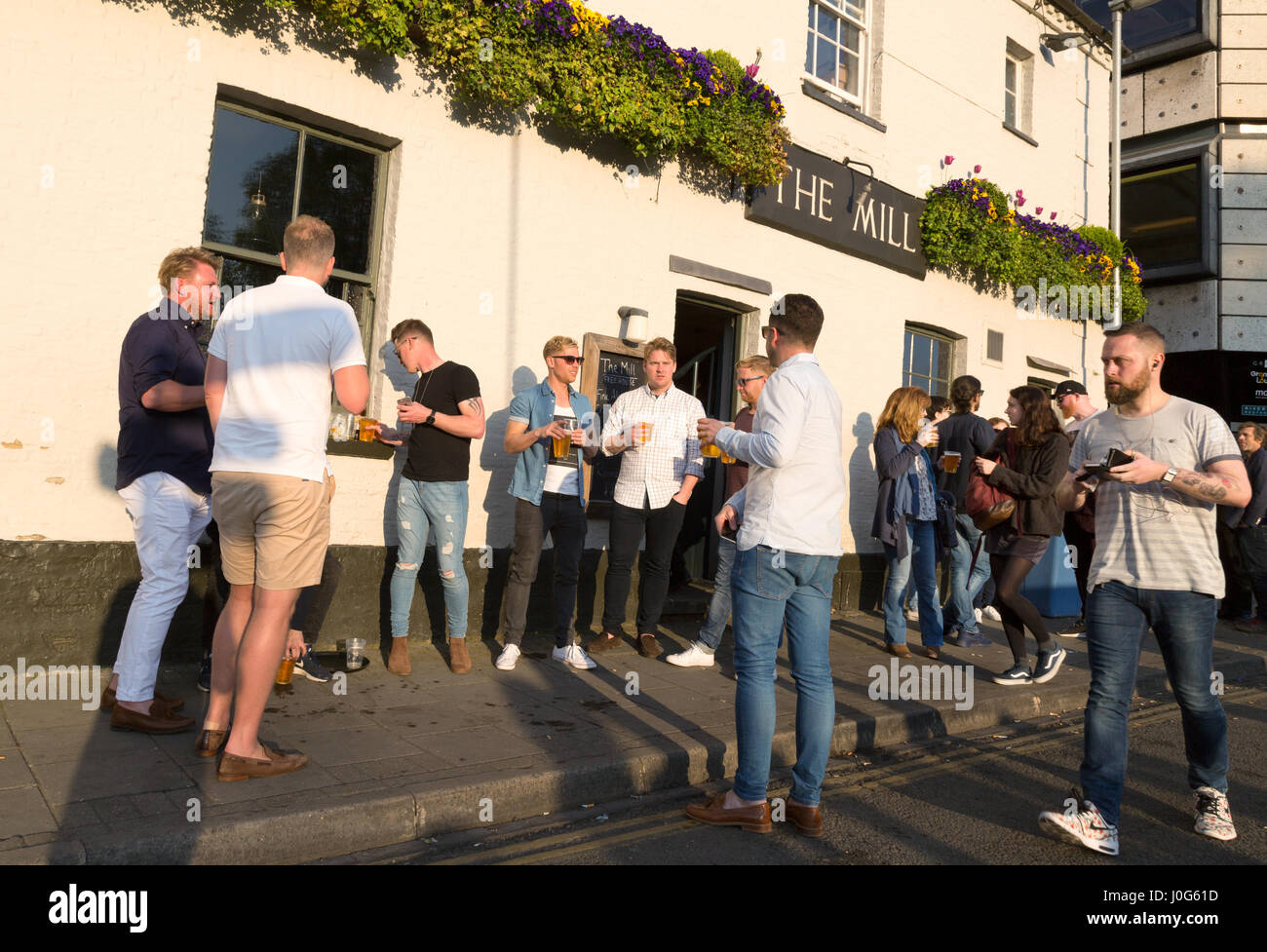 Männer trinken Bier UK, vor der Mühle Pub, Mill Lane, Cambridge UK Stockfoto