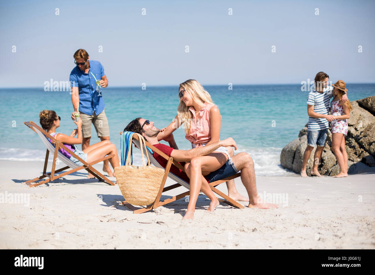 Junge Pärchen am Ufer am Strand im sonnigen Tag Stockfoto