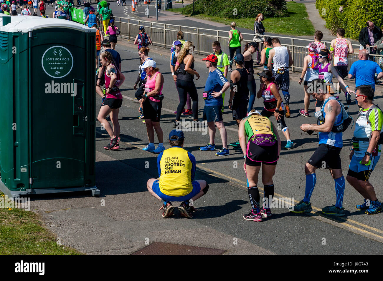 Athleten, die Teilnahme an der Brighton Marathon Warteschlange für Toiletten, Brighton, Sussex, Großbritannien Stockfoto