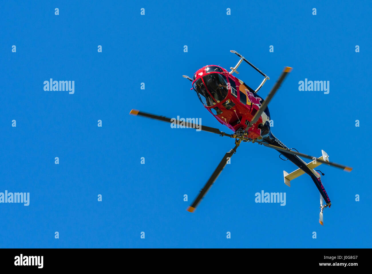 Rot Hubschrauber in der Luft Vorderansicht, in Richtung Betrachter auf einfachen Hintergrund Durchführung Kunstflug Manöver, Flying Bulls aerobatic Display Team Stockfoto
