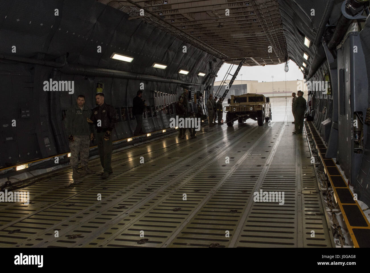 US Air Force Besatzungsmitglieder für die 22. Luftbrücke Geschwader arbeiten, um zu laden und sichern eine hohe Mobilität Mehrzweck Rädern Fahrzeug (HMMWV) in eine C5-M Super Galaxy Flugzeug während der Arbeiten mit Flieger-Programm, 7. April 2017. Das Programm beinhaltet Flügel Führung Interaktion mit Flieger zu bekommen einen detaillierten Überblick über jede Mission an Travis durchgeführt. (Foto der US Air Force / Heide Couch) Stockfoto