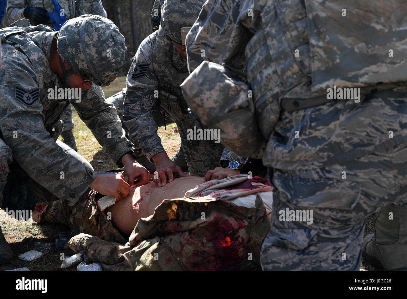 Studenten der 435th Security Forces Squadron Ground Combat Readiness Training Center Security Operations Kurs leisten Hilfe zu einem simulierten verletzten Flieger während der tactical combat Casualty Care Teil des Kurses auf der Ramstein Air Base, Deutschland, 30. März 2017. Die zwei-Wochen-Kurs soll Sicherheitskräfte Flieger vorbereiten, die Reihe bereitstellen.  Flieger, die 86. SFS, 422. SFS 100. SFS und 569th US Kräfte Polizei Geschwader zugewiesen beteiligte sich an den Kurs. (Foto: Senior Airman Tryphena Mayhugh US Air Force) Stockfoto