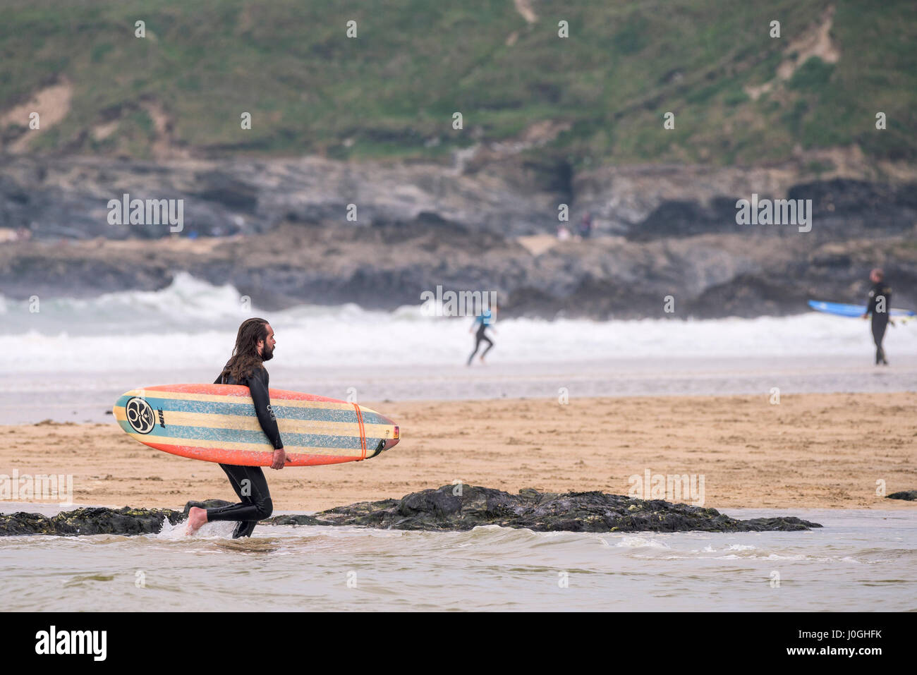 Gwithian Towans beach Surfer verlassen das Meer Meer tragen Surfbrett Küste Küste Longboard Urlauber Freizeit Urlaub Aktivität Stockfoto