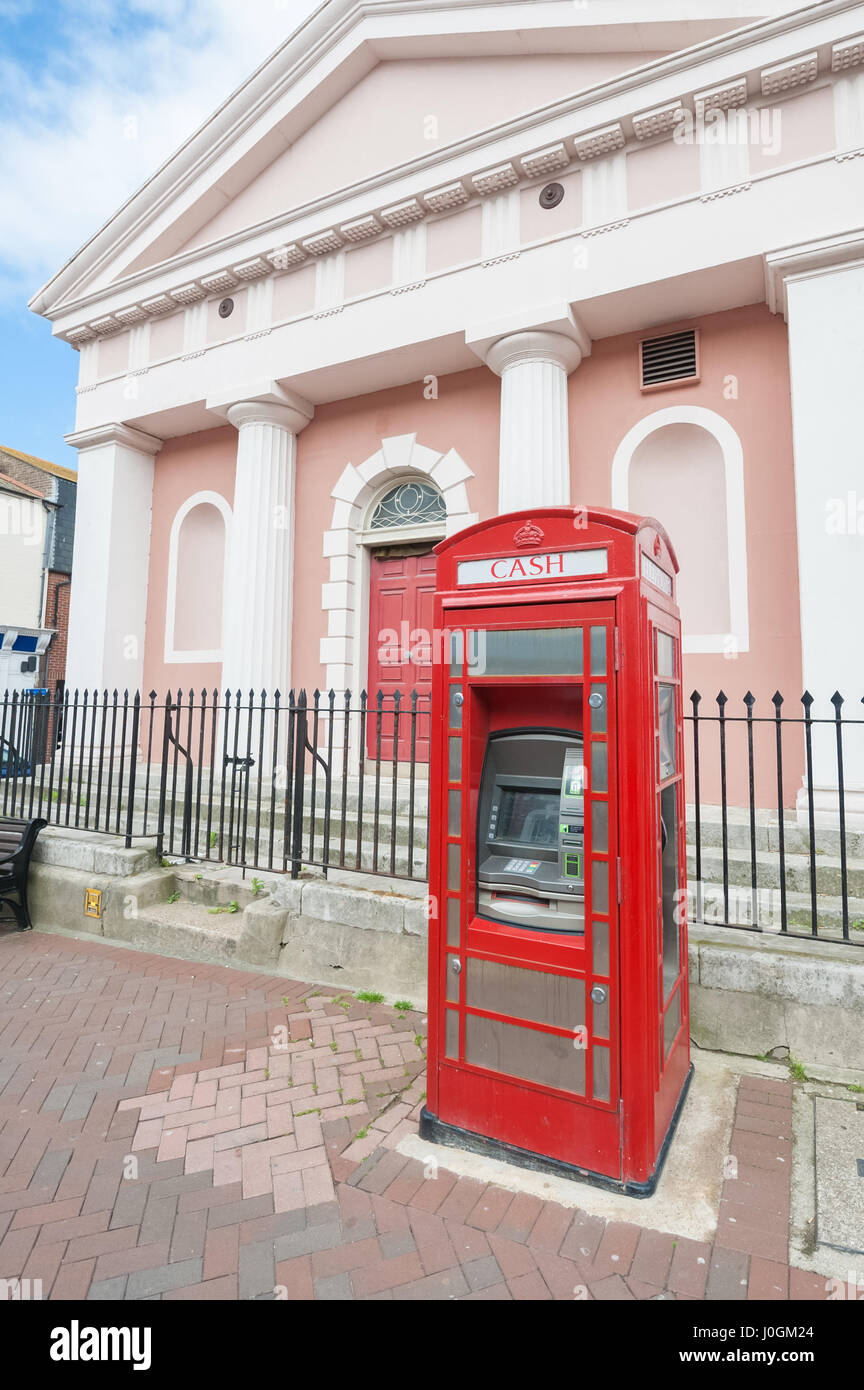 Vintage rote Telefonzelle umgewandelt in einen Geldautomaten in Weymouth, Großbritannien - 13. Juni 2013 Stockfoto