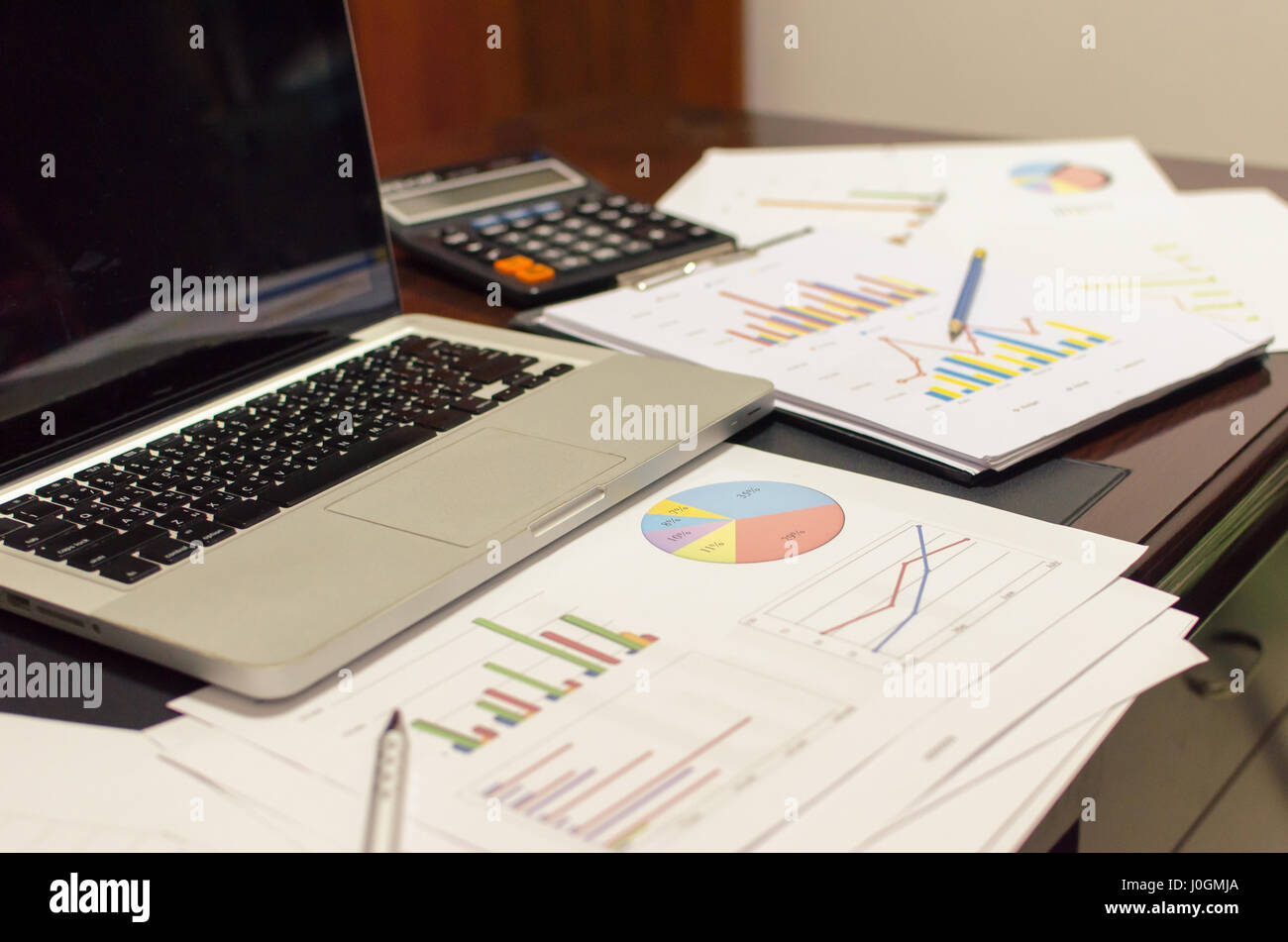 Dokumente auf Schreibtisch mit Laptop-Computer und Grafik finanzielle mit sozialen Netzwerk-Diagramm Stockfoto