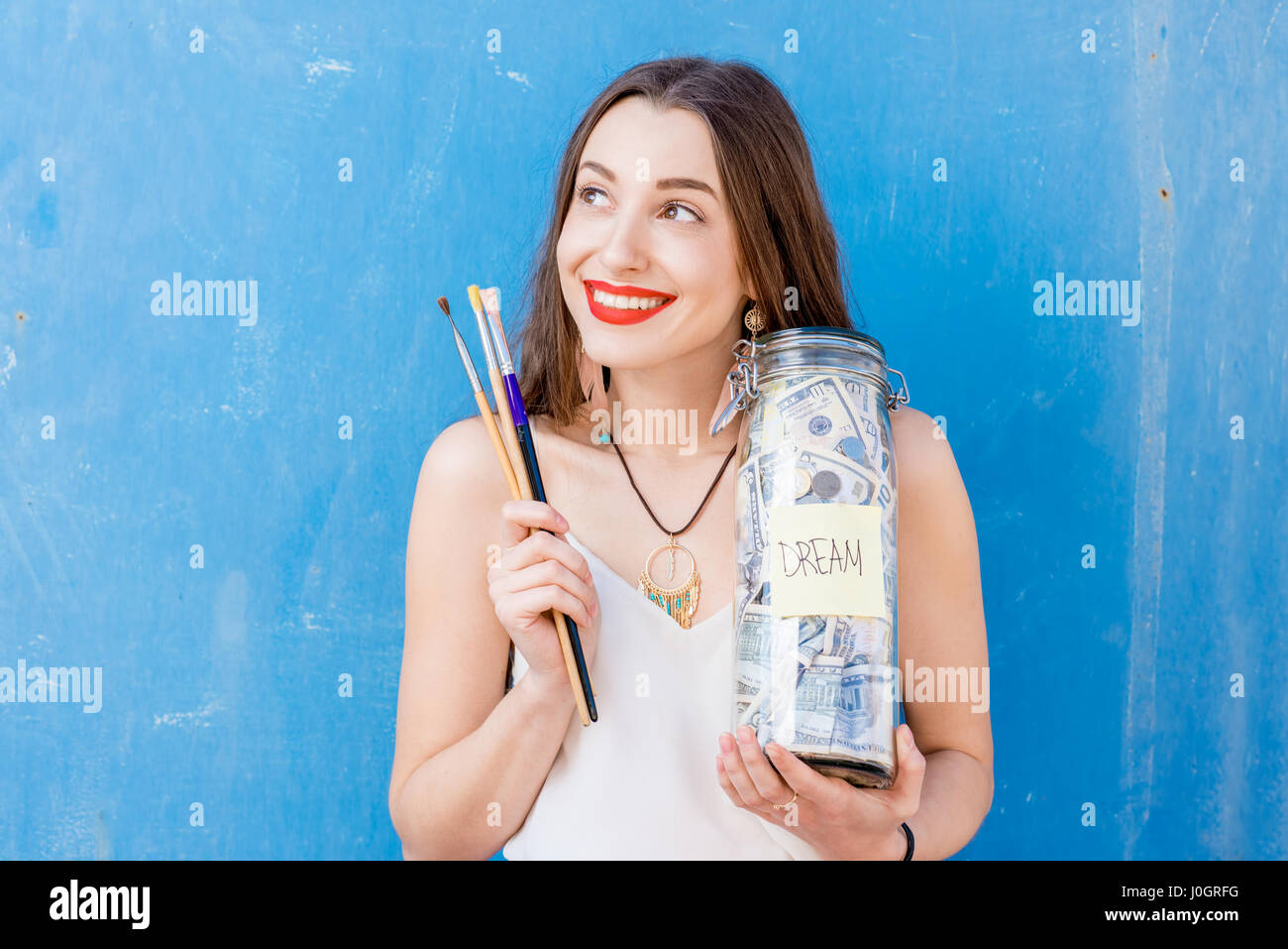 Frau hält eine Flasche voller Geld sparen Stockfoto