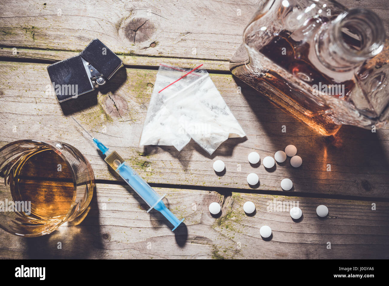 Overhead Schuss von harten Drogen und Alkohol auf Holztisch. Sucht-Konzept Stockfoto