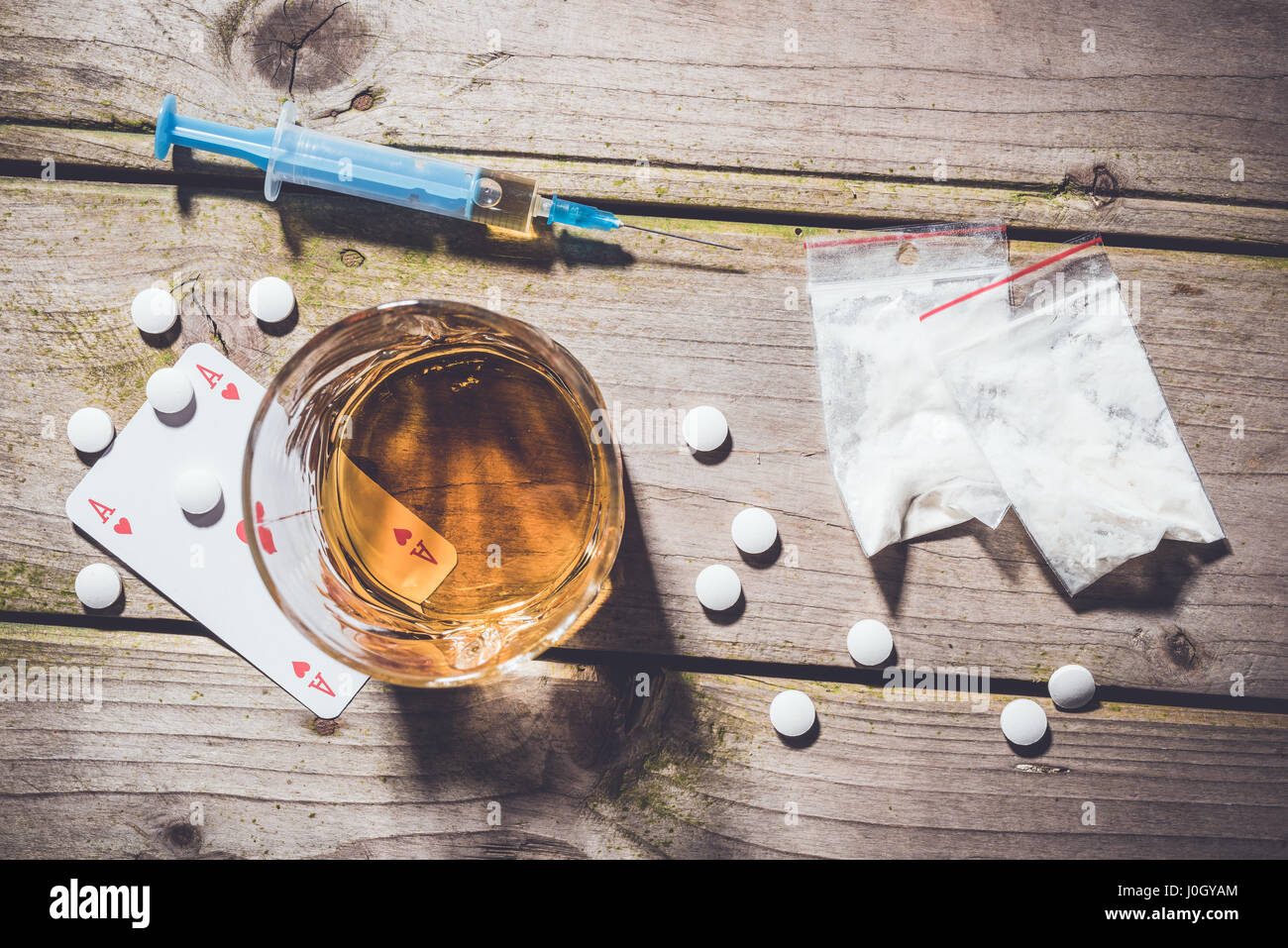 Overhead Schuss von harten Drogen und Alkohol auf Holztisch. Sucht-Konzept Stockfoto