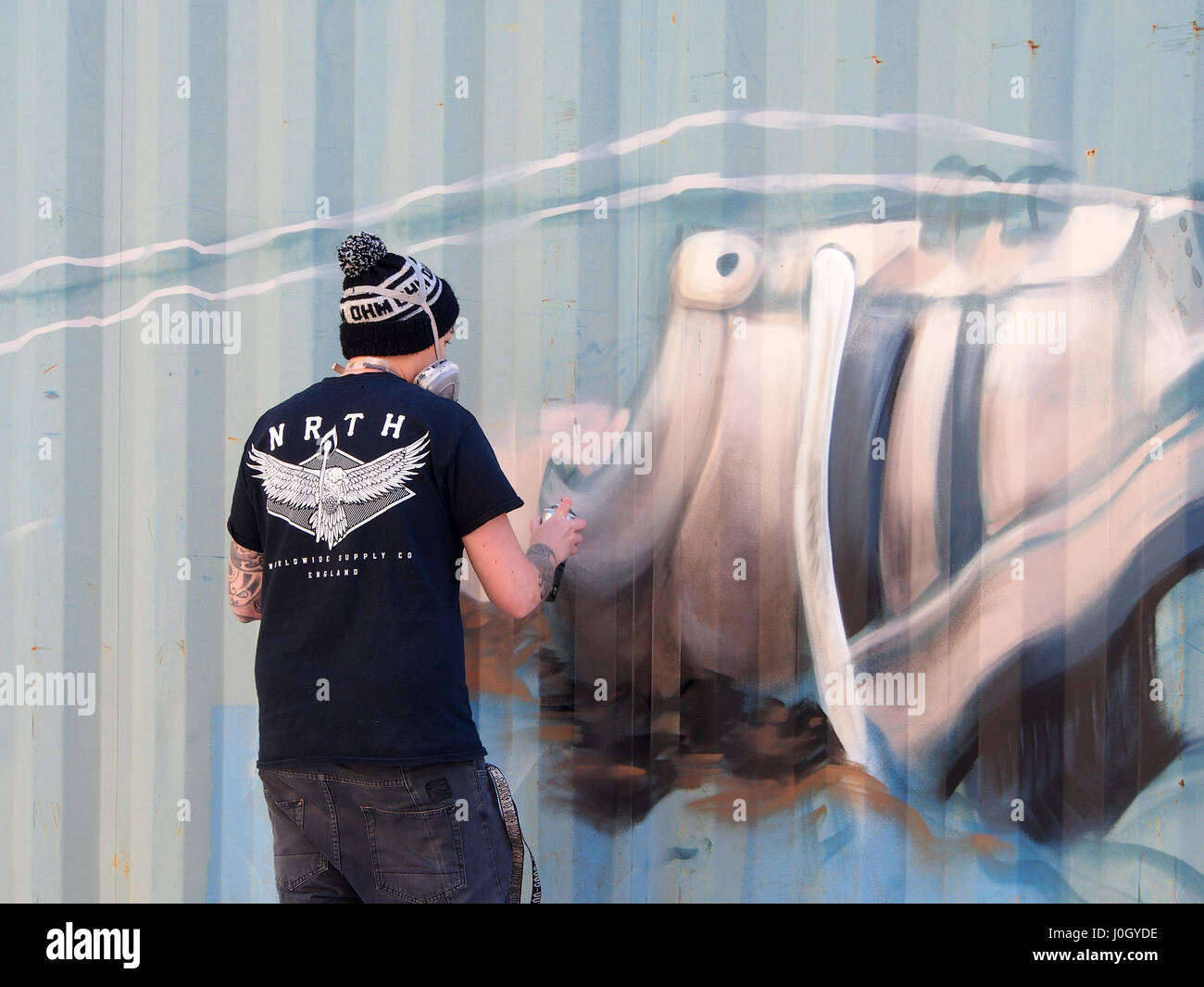 Legale Graffiti, Grafitti, Graffiti, ein junger Mann gibt eine Demonstration der Malerei mit Spray Farbe auf einem Behälter im St.-Anna Platz in Manchester, Stockfoto