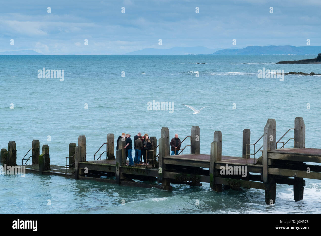 Aberystwyth Wales UK, Donnerstag, 13. April 2017 UK Wetter: Menschen auf dem Meer Steg an einem kalten aber hellen und luftigen Tag in Aberystwyth, Wales, am Vorabend des Ostern Bank Holiday Wochenende Bildnachweis: Keith Morris/Alamy Live News Stockfoto